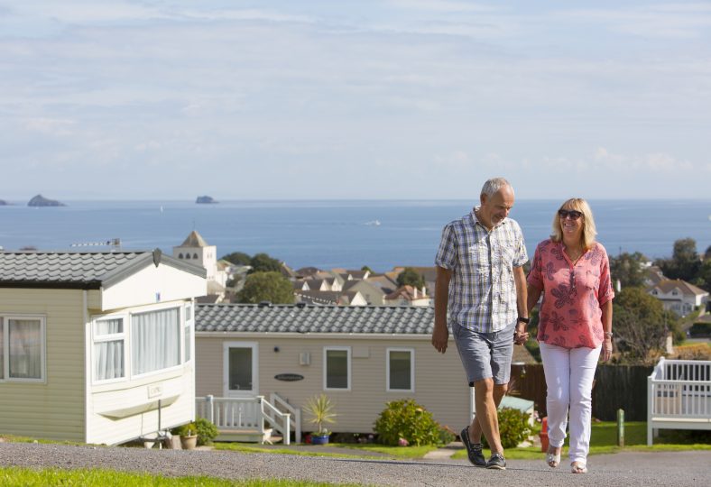 Arrange a Visit. Holiday home owners with a sea view in background
