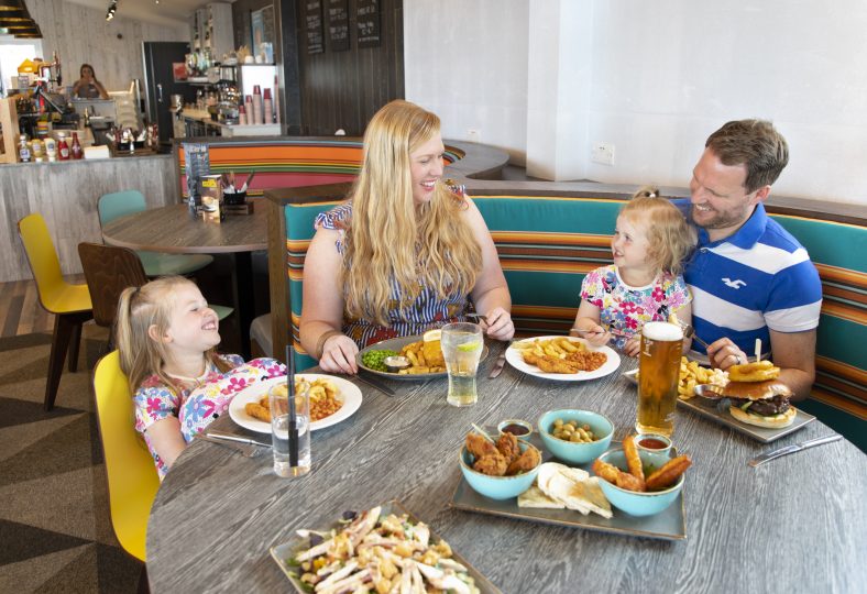 Food & Drink at Beverley Holidays - Family eating together around a table at the Jetty Lounge.