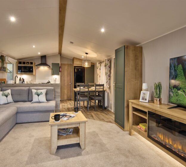 Cozy interior of a static home featuring a large TV, comfortable sofa, stylish dining area, and modern kitchen with all essential appliances.