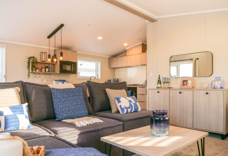 faraday living area - open plan with view of kitchen in background and hanging festoon lights.