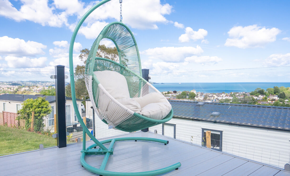 Regal Harbour luxury lodge with an egg chair on the decking