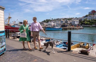 Couple walking dog around Brixham Harbour