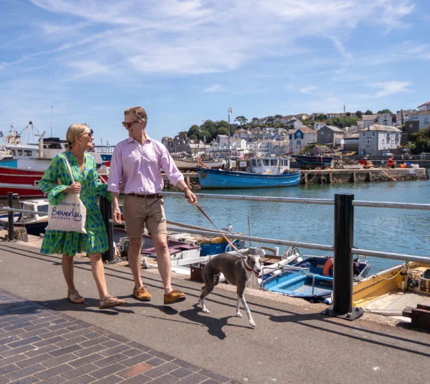 Couple walking dog around Brixham Harbour