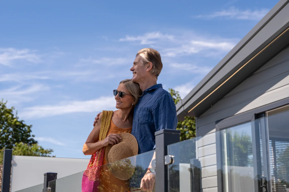 Older couple standing together on lodge decking at Harbour Heights