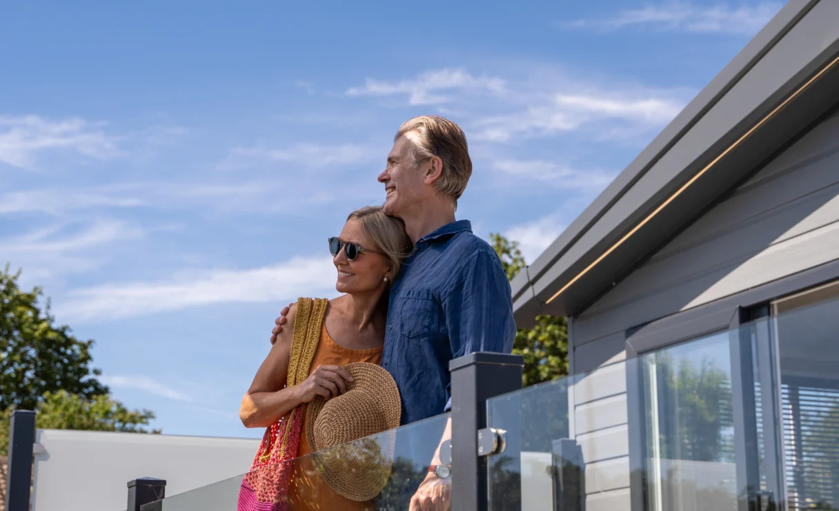 Older couple standing together on lodge decking at Harbour Heights