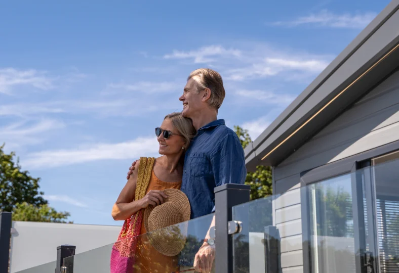Older couple standing together on lodge decking at Harbour Heights